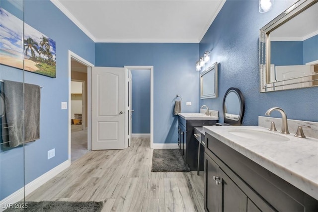 bathroom with ornamental molding, hardwood / wood-style flooring, and vanity