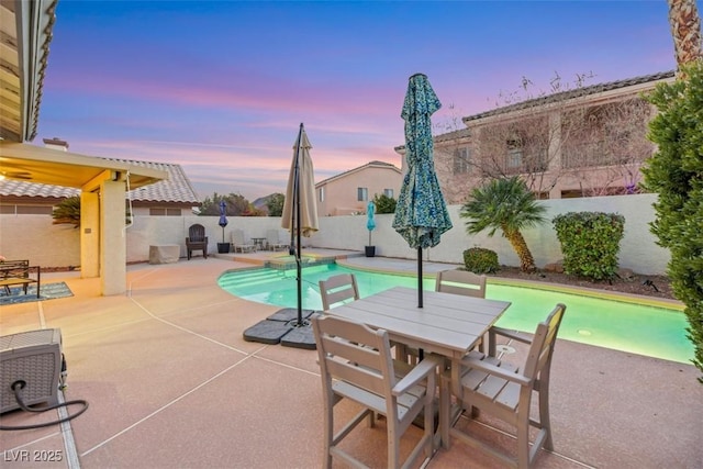 pool at dusk featuring a patio