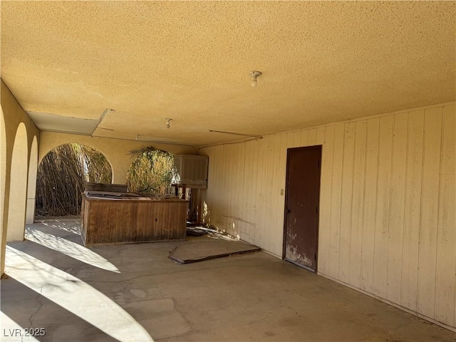 miscellaneous room with a textured ceiling and wooden walls