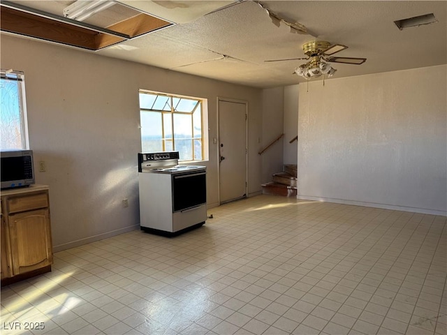 kitchen featuring ceiling fan, white range with electric stovetop, and a textured ceiling