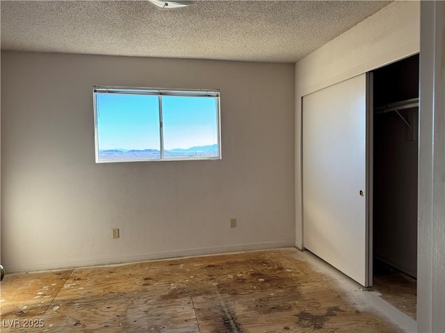 unfurnished bedroom with a textured ceiling and a closet