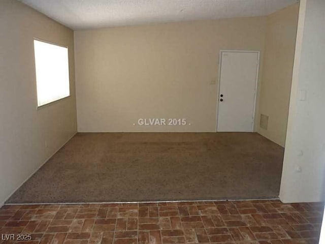 spare room with dark carpet