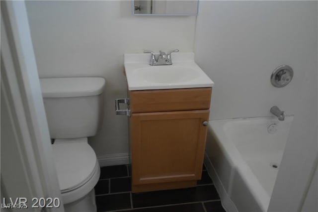 bathroom with toilet, vanity, and a tub to relax in