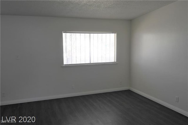 empty room featuring a textured ceiling and dark wood-type flooring