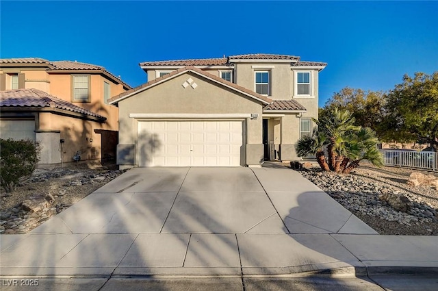 mediterranean / spanish house featuring driveway, an attached garage, a tile roof, and stucco siding