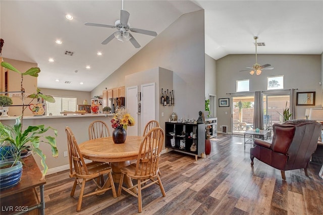 dining space with high vaulted ceiling, ceiling fan, and hardwood / wood-style floors