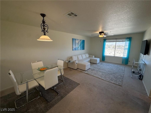 dining space featuring ceiling fan, a textured ceiling, and carpet flooring