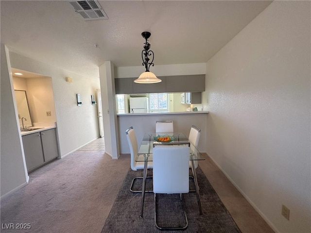 carpeted dining space with sink