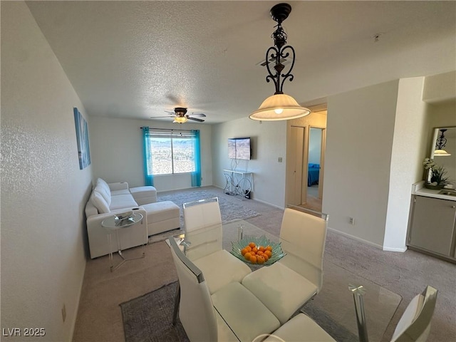 living room with light carpet, ceiling fan, and a textured ceiling