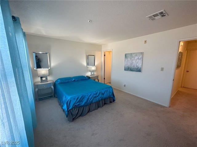 bedroom featuring light carpet and a textured ceiling