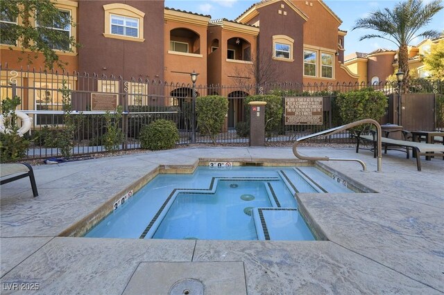 view of pool with a hot tub