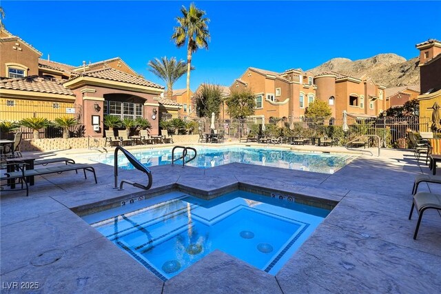 view of pool featuring a mountain view, a patio area, and a hot tub