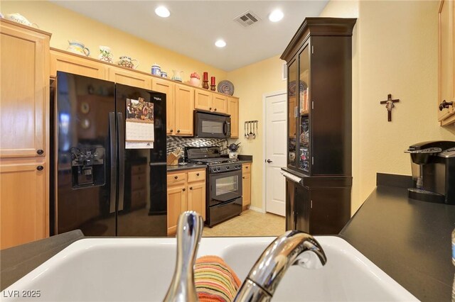 kitchen with decorative backsplash, light brown cabinets, and black appliances