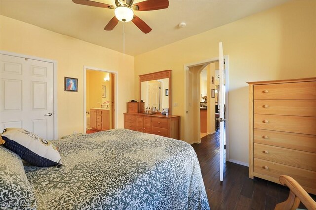 bedroom with ceiling fan, dark wood-type flooring, and ensuite bath