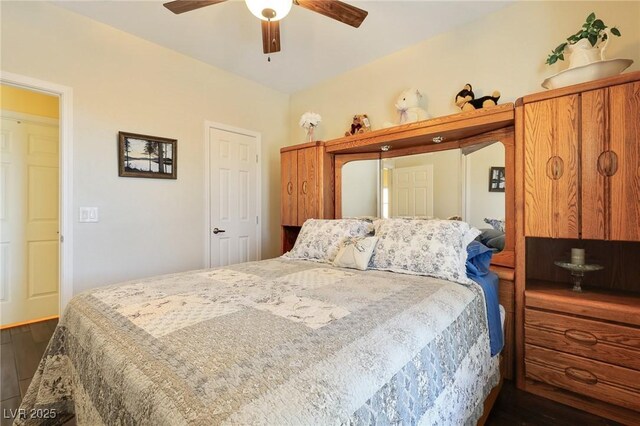 bedroom featuring ceiling fan and dark wood-type flooring