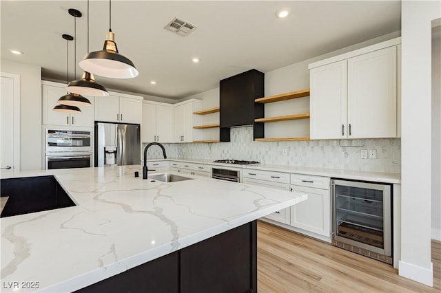 kitchen featuring pendant lighting, white cabinetry, appliances with stainless steel finishes, and beverage cooler