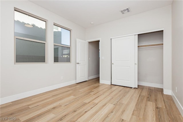 unfurnished bedroom with light hardwood / wood-style flooring and a closet