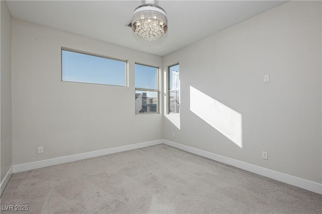 empty room with an inviting chandelier and light carpet