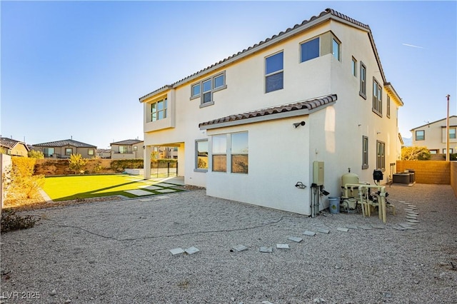 rear view of property with cooling unit, a yard, and a patio area