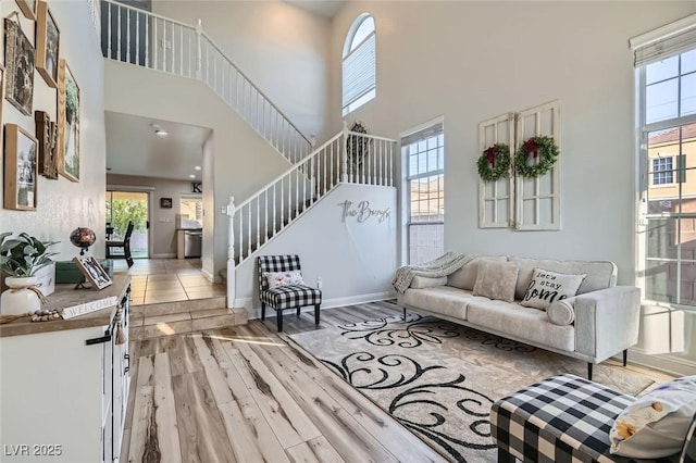 living room featuring a high ceiling and light hardwood / wood-style flooring