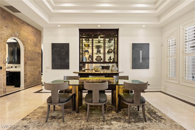 tiled dining room featuring a raised ceiling