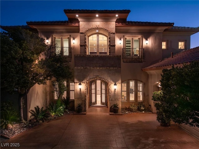 view of front of house with french doors and a balcony