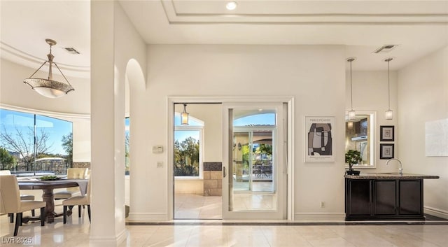 doorway to outside with light tile patterned flooring, plenty of natural light, and sink