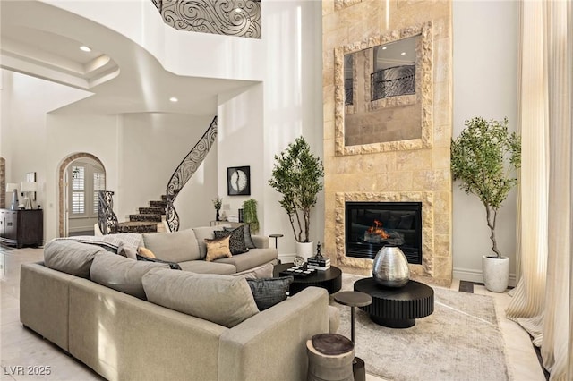 tiled living room featuring a tiled fireplace and a towering ceiling