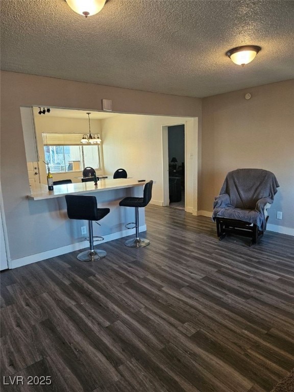 interior space featuring hanging light fixtures, dark hardwood / wood-style floors, and a textured ceiling