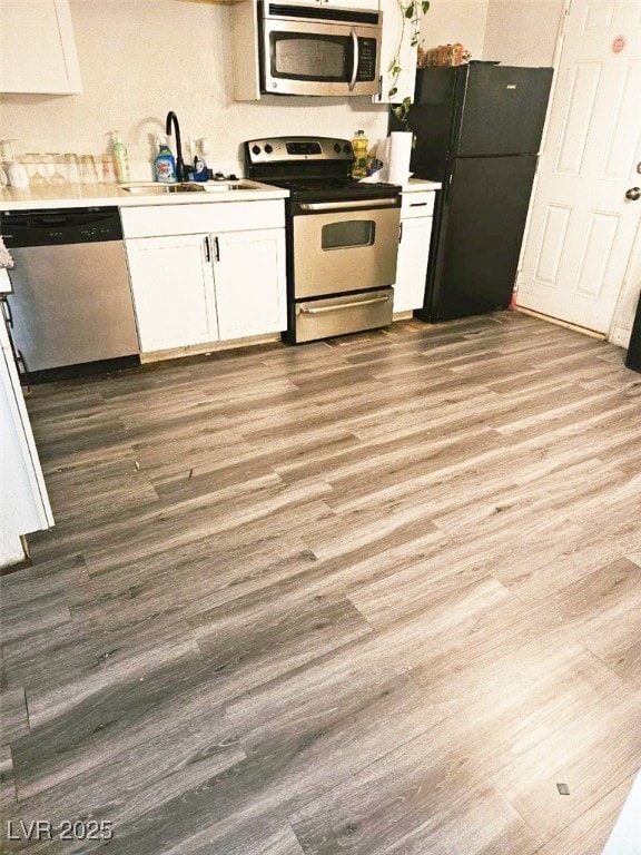 kitchen featuring sink, light wood-type flooring, white cabinetry, and stainless steel appliances