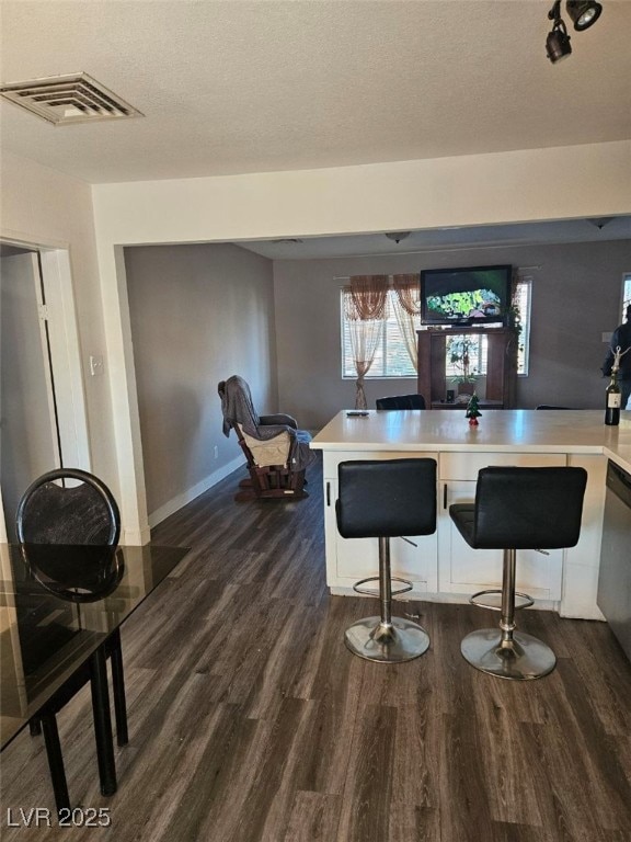 bar featuring dishwasher, dark hardwood / wood-style floors, and a textured ceiling