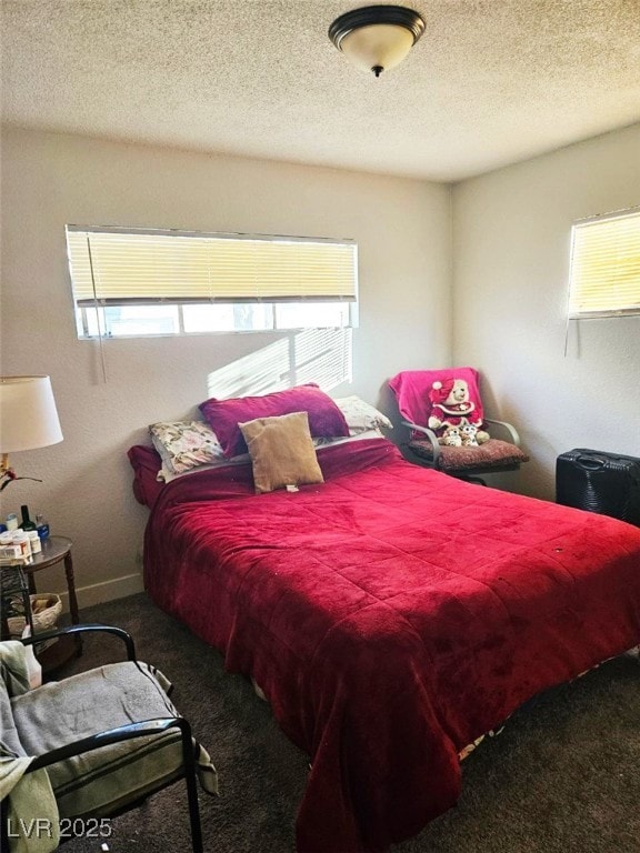 carpeted bedroom with multiple windows and a textured ceiling