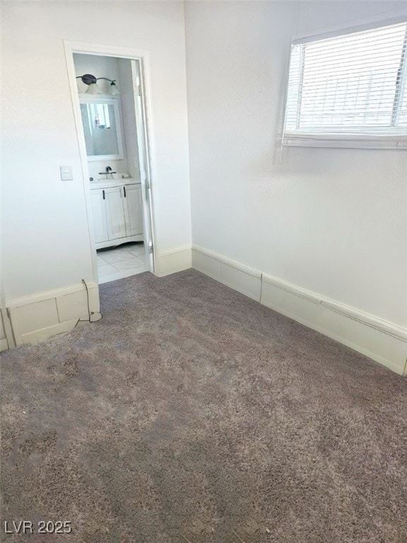 empty room featuring sink and light carpet