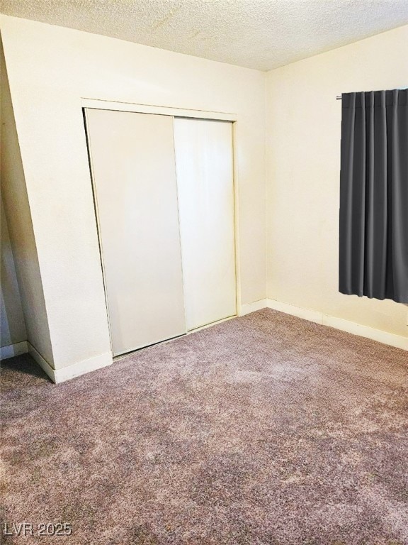 unfurnished bedroom featuring carpet, a closet, and a textured ceiling