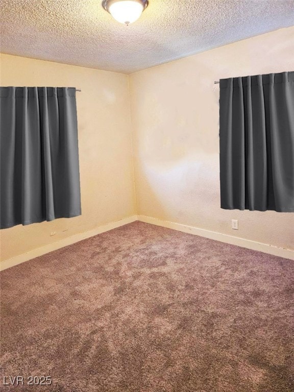 spare room with a textured ceiling and carpet flooring