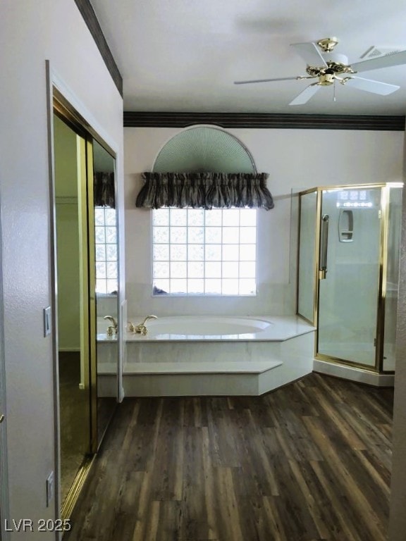 bathroom featuring ceiling fan, hardwood / wood-style flooring, plus walk in shower, and ornamental molding