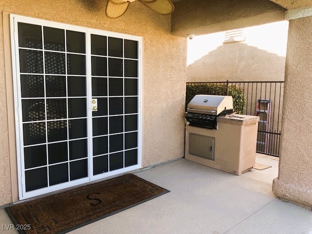 doorway to property with ceiling fan and a patio