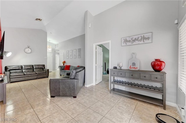 living room with high vaulted ceiling and light tile patterned flooring