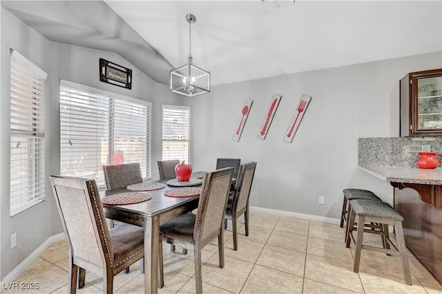 dining room with light tile patterned floors, a chandelier, and vaulted ceiling