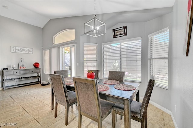 dining space featuring a notable chandelier, light tile patterned floors, and lofted ceiling