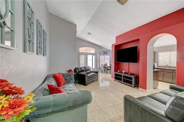 living room with sink, a wealth of natural light, light tile patterned floors, and lofted ceiling