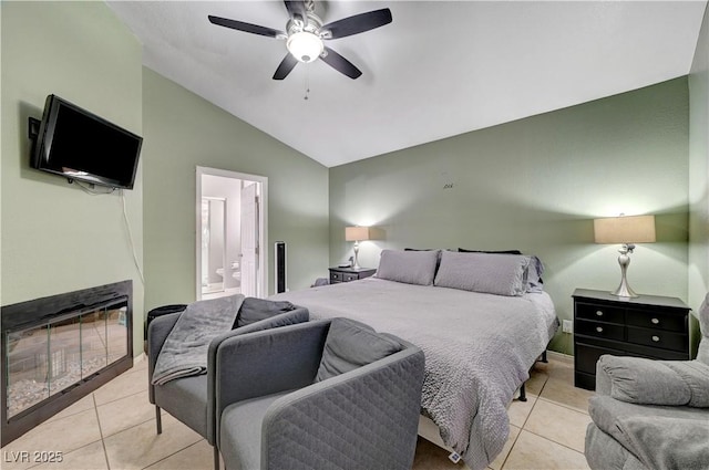 bedroom featuring lofted ceiling, ensuite bathroom, light tile patterned floors, and ceiling fan