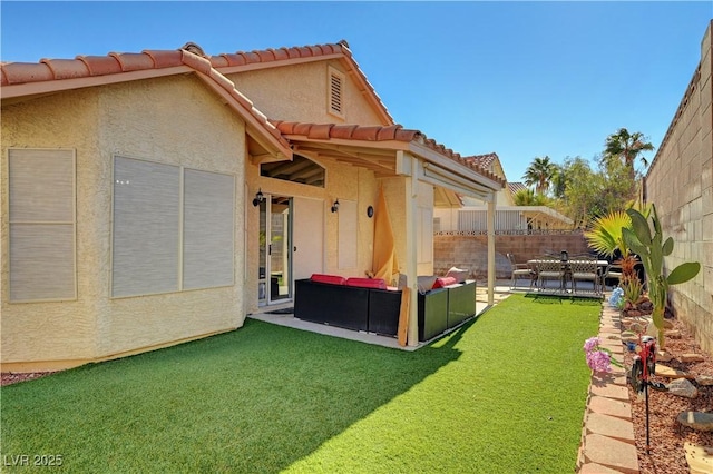 rear view of house with an outdoor living space, a lawn, and a patio