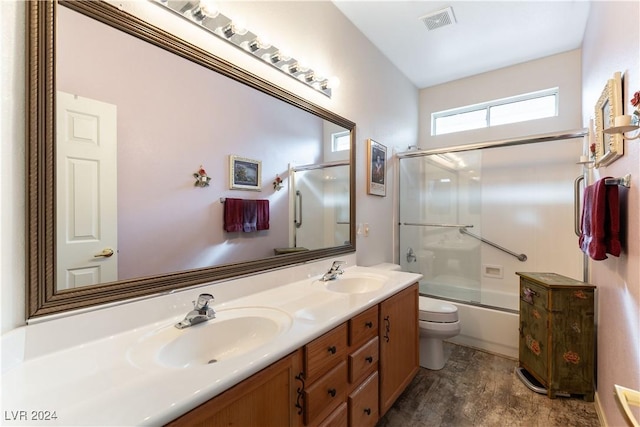 full bathroom featuring combined bath / shower with glass door, vanity, and toilet