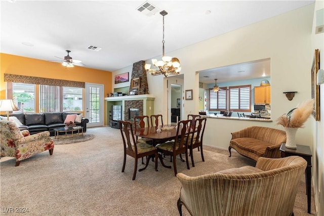 carpeted dining area with ceiling fan with notable chandelier