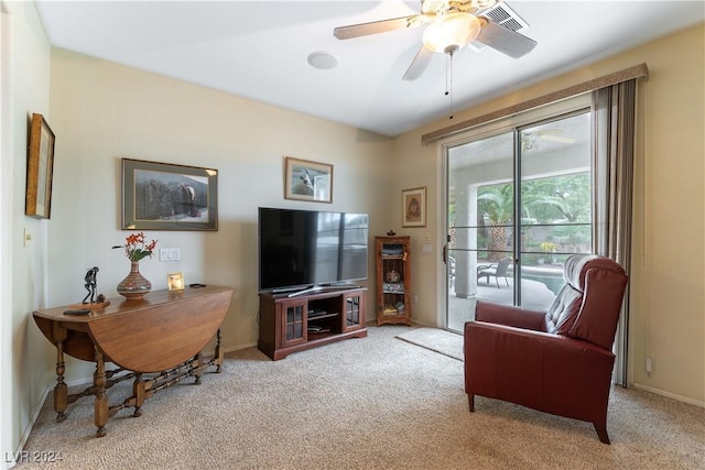 living area featuring light carpet and ceiling fan