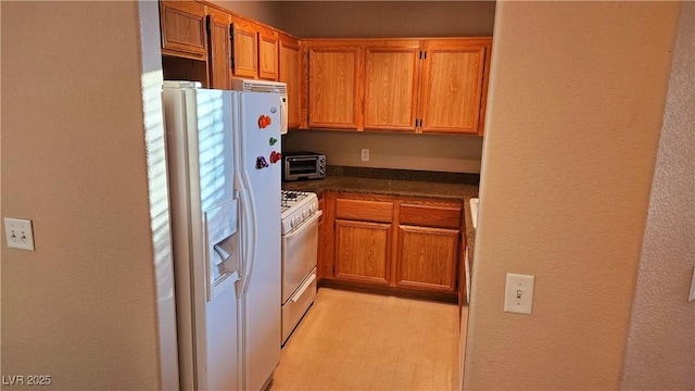 kitchen with white appliances and light hardwood / wood-style floors