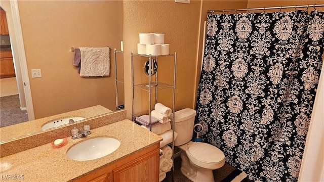 bathroom with vanity, curtained shower, and toilet