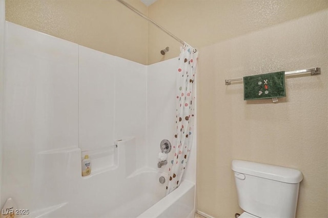 bathroom featuring shower / bath combination with curtain and toilet