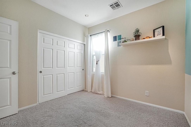 unfurnished bedroom featuring carpet and a closet